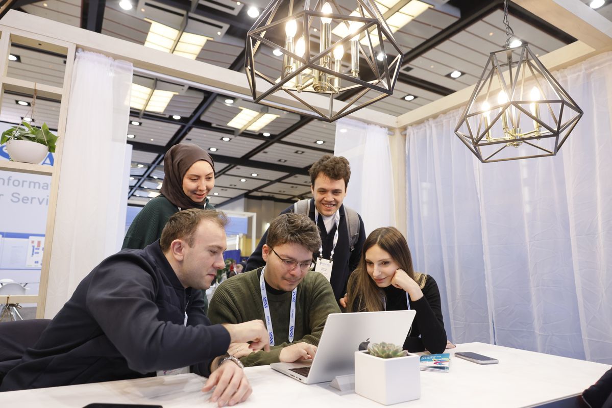 Attendees collaborating around a laptop at RSNA